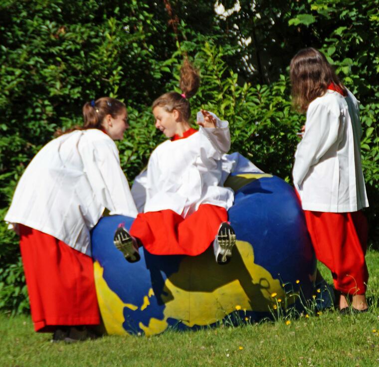 Ministranten auf einem Weltkugelball